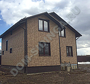 Дом обшит фасадными панелями Grand Line Крымский